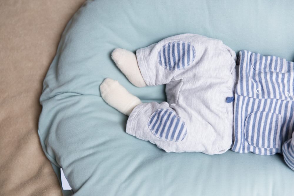 Baby sleeping comfortably with socks on – safe newborn sleep tips