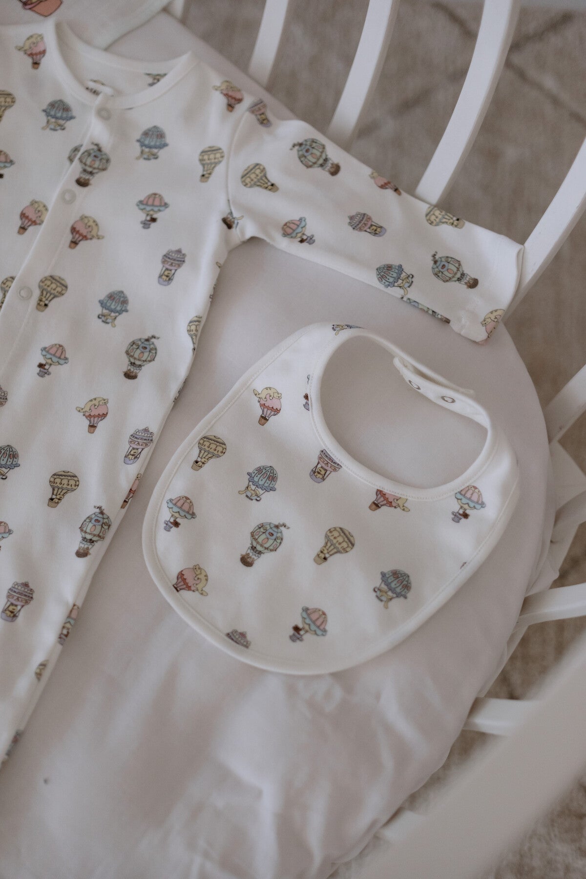 Matching newborn hat and bib in hot air balloon theme, made from GOTS-certified fabric