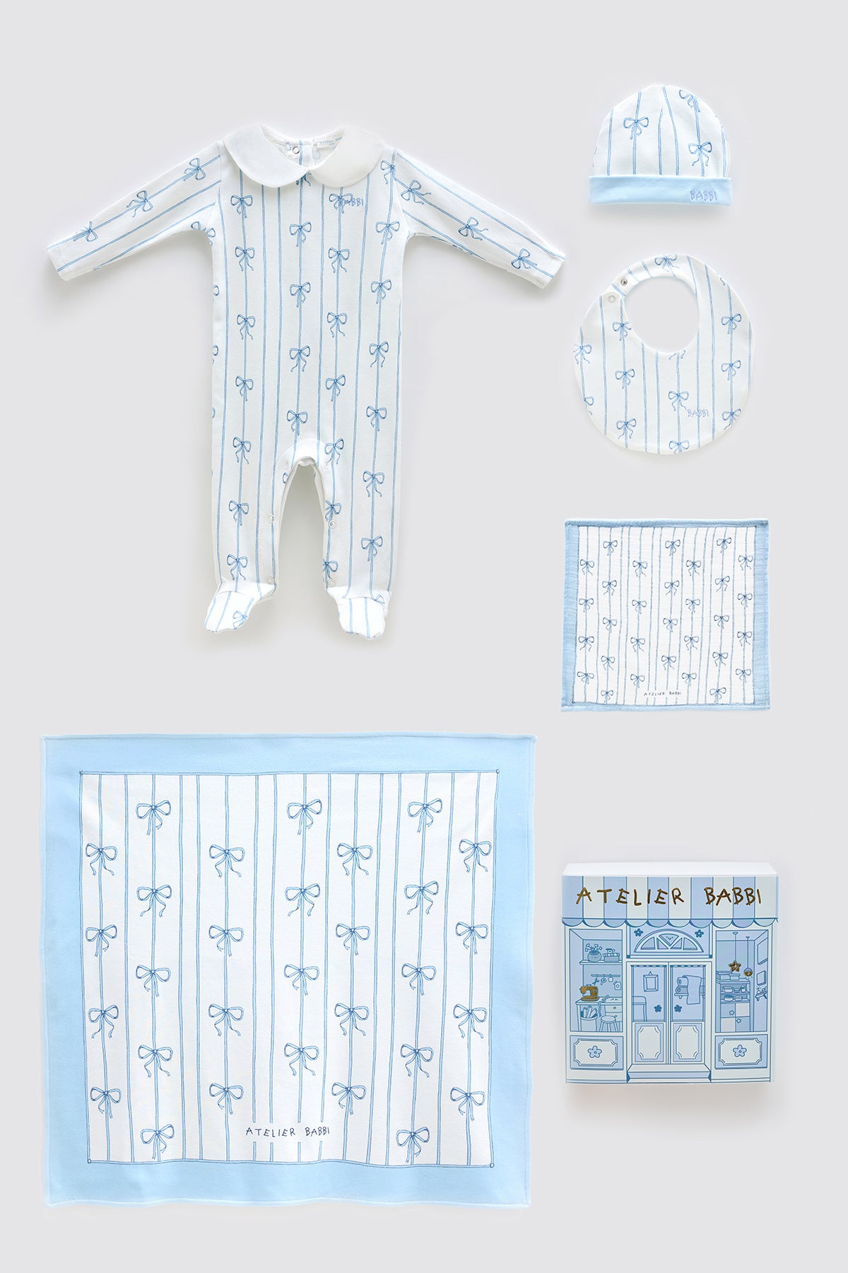 Elegant Blue Ribbon newborn gift set featuring a soft muslin blanket, matching onesie, bib, hat, and pacifier cloth — all crafted from 100% organic cotton with delicate blue bow details.