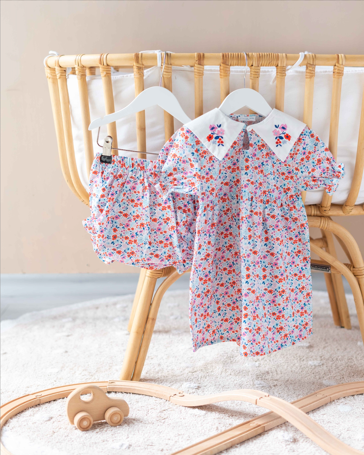 Baby dress with tiny red flower print, made from soft cotton for everyday comfort.