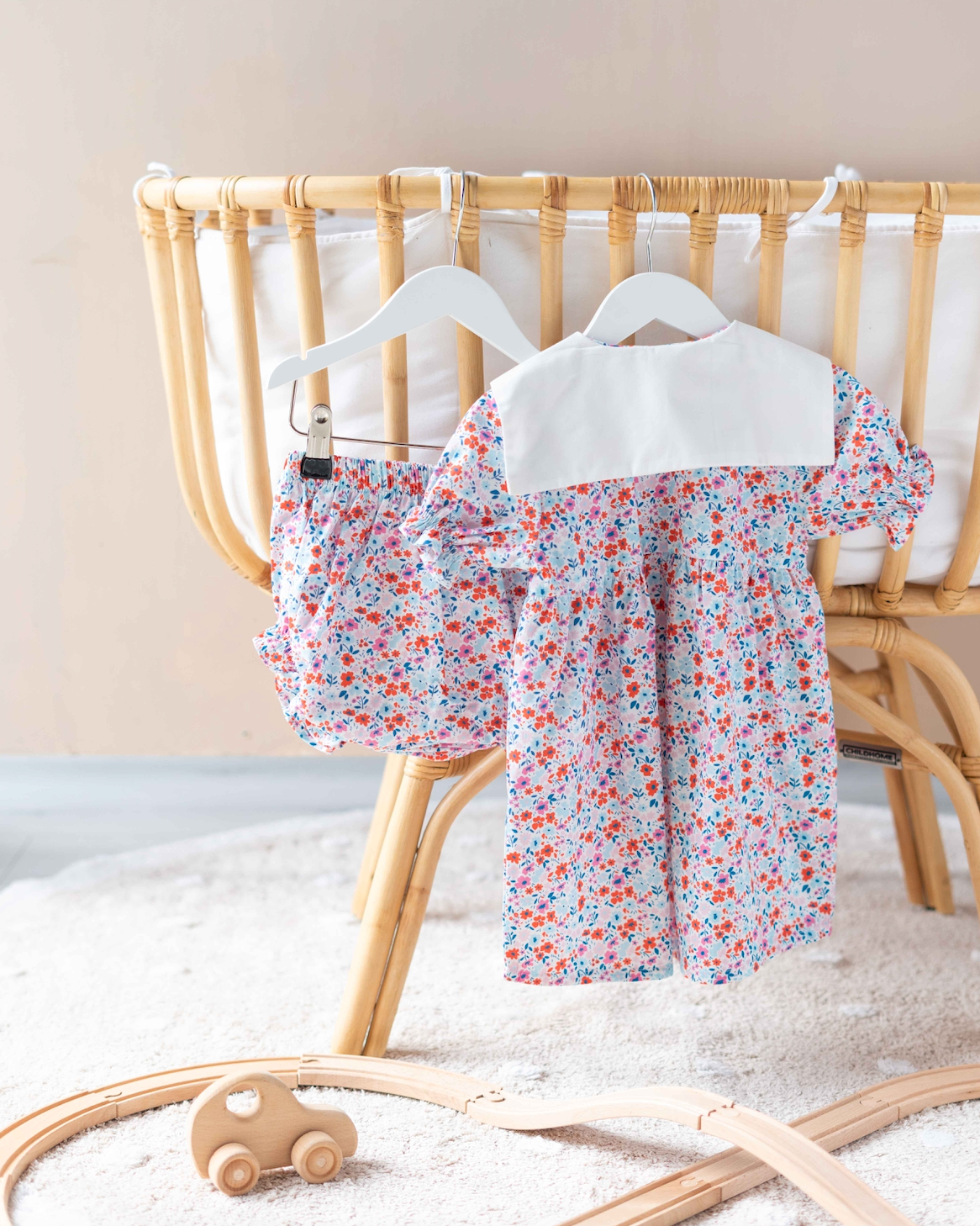Close-up of delicate red floral pattern on a baby dress from the Tiny Flowers collection.