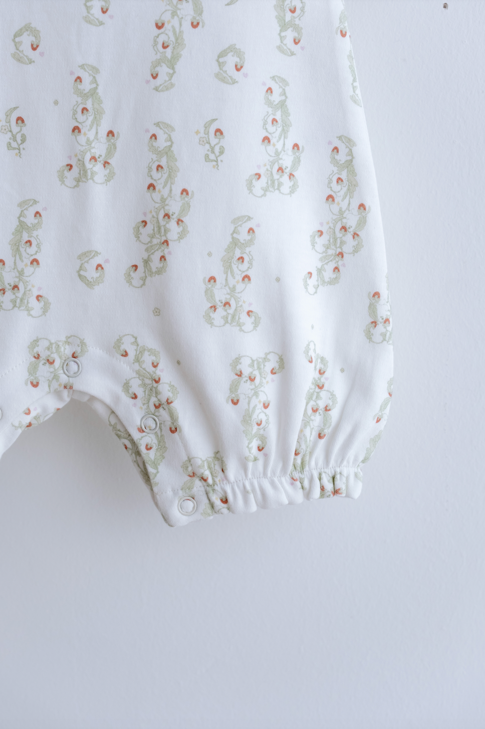 Close-up of delicate embroidery on Atelier Babbi’s strawberry baby outfit