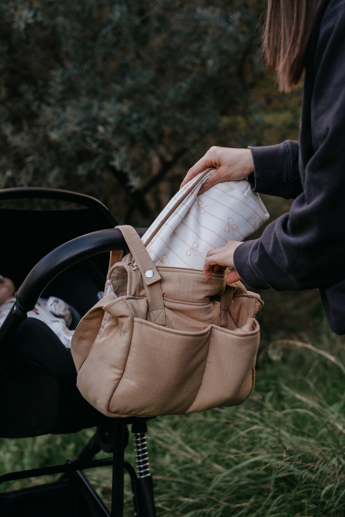 Open muslin diaper bag showing spacious interior and baby essentials
