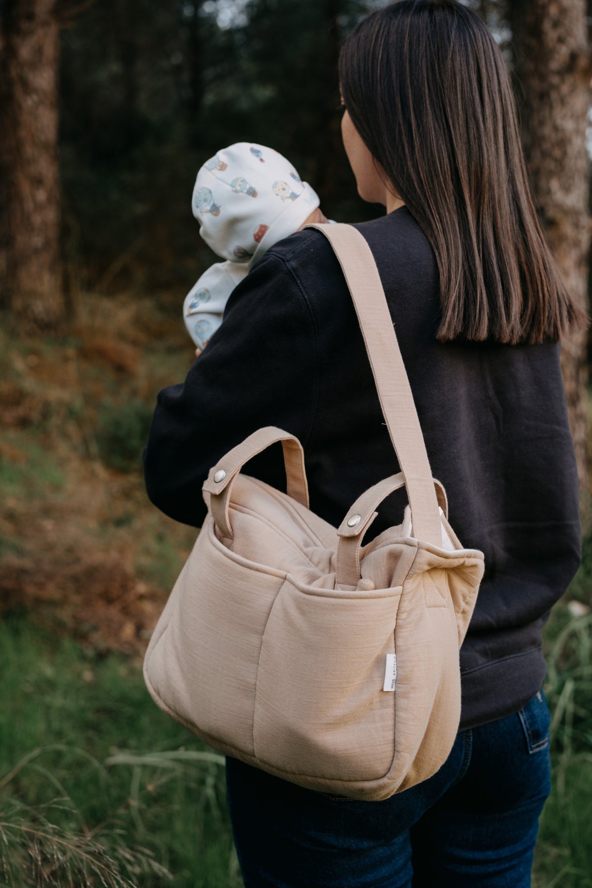 Side view of mommy bag with adjustable shoulder strap and outer pocket