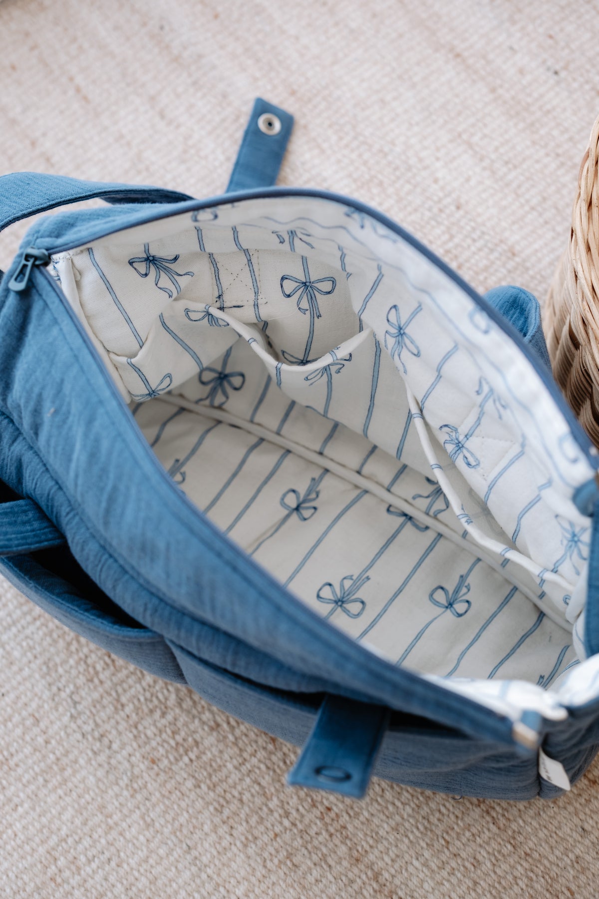 Open muslin diaper bag showing spacious interior and baby essentials