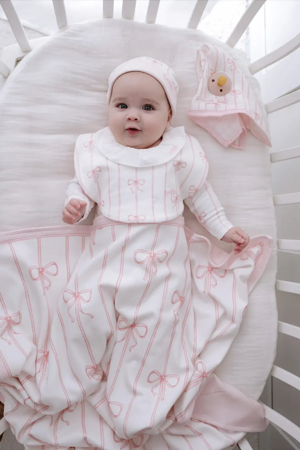 Baby essentials set featuring pink ribbon onesie folded neatly