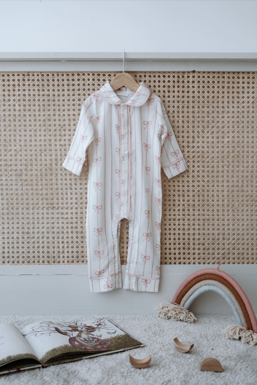 Pink baby jumpsuit with subtle ribbon print