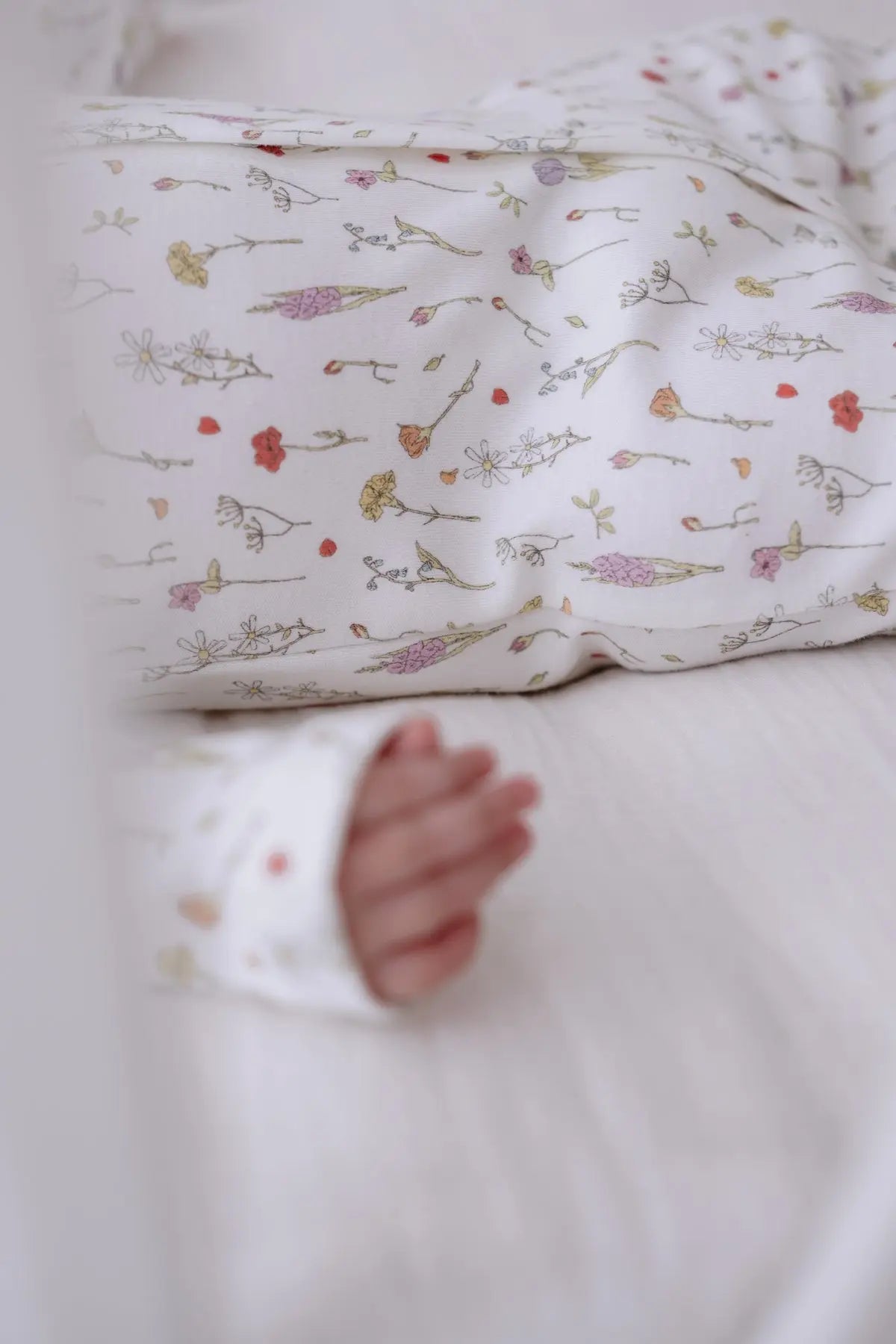 Soft newborn sleeper with pastel spring flowers