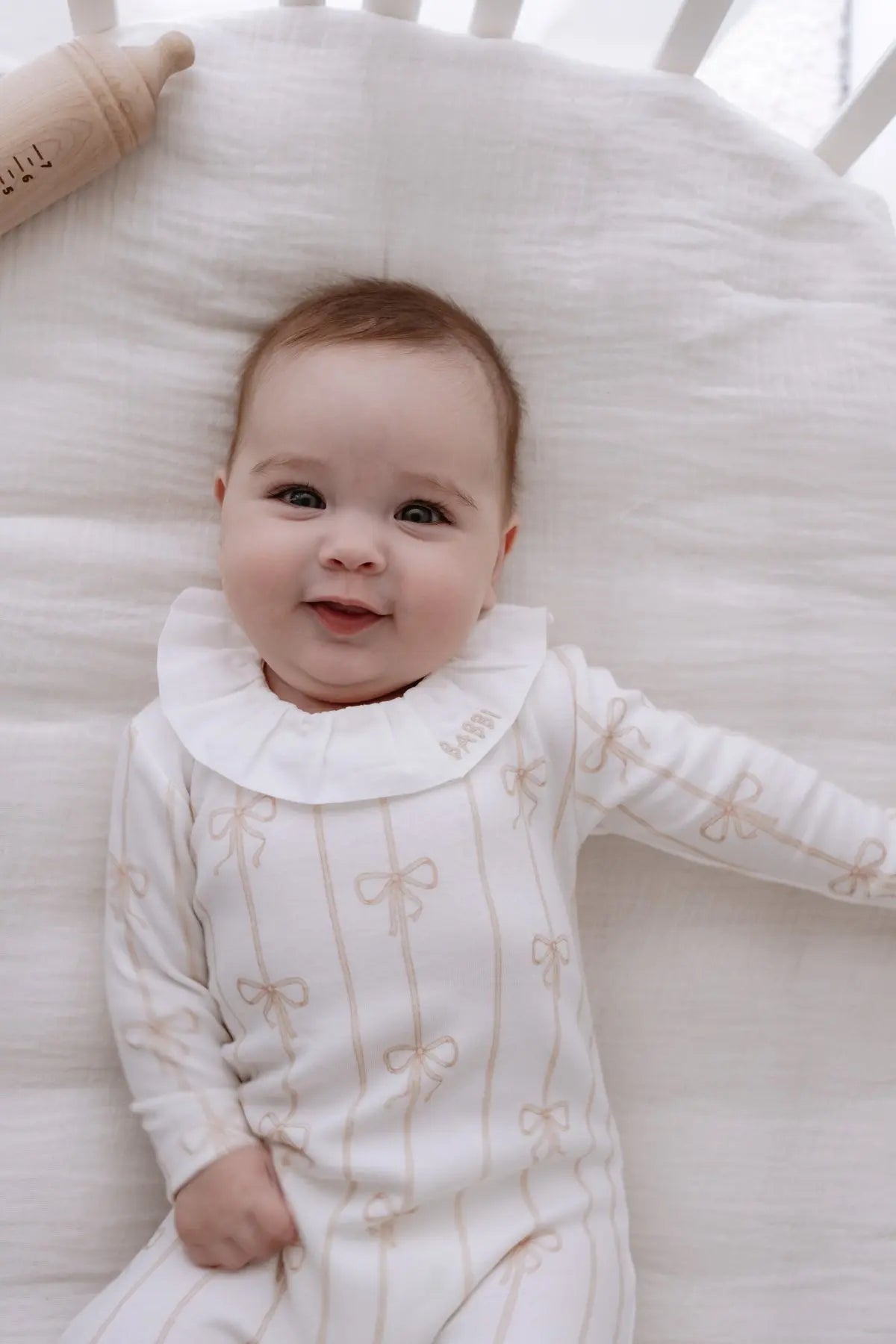 Beige ribbon baby footed onesie