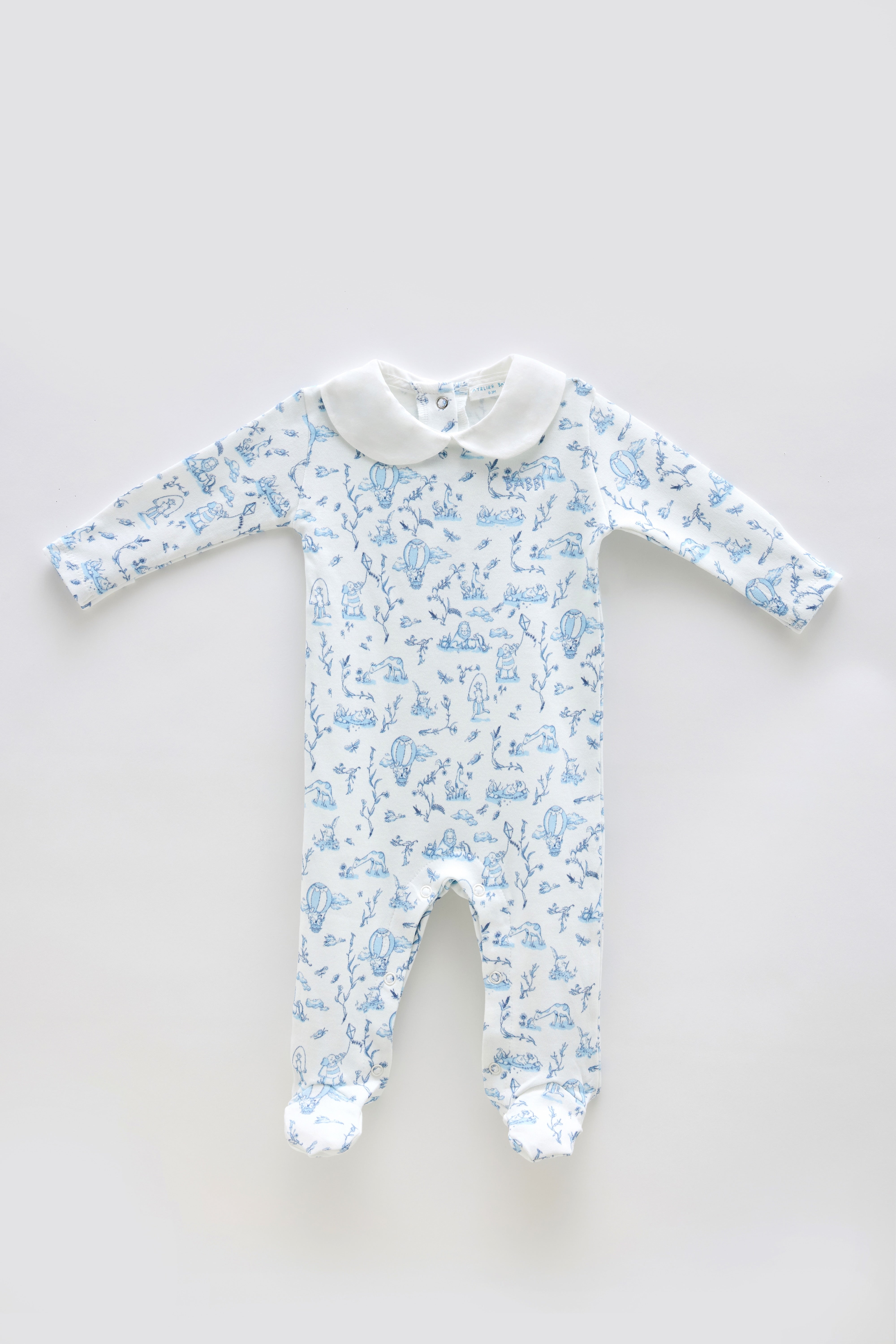 Baby onesie with blue toile pattern on a light gray background