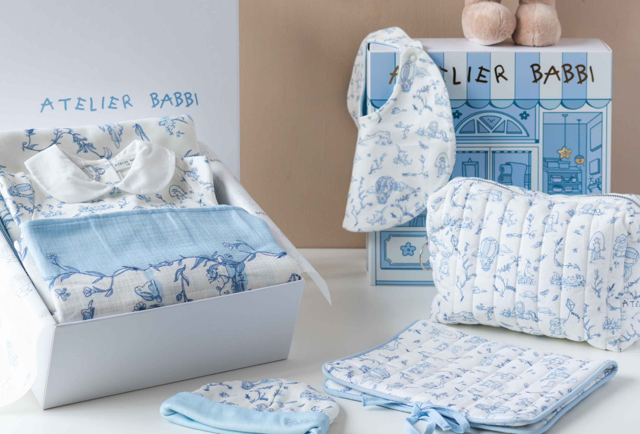 Baby products with blue and white patterns displayed in front of an Atelier Babbi box.