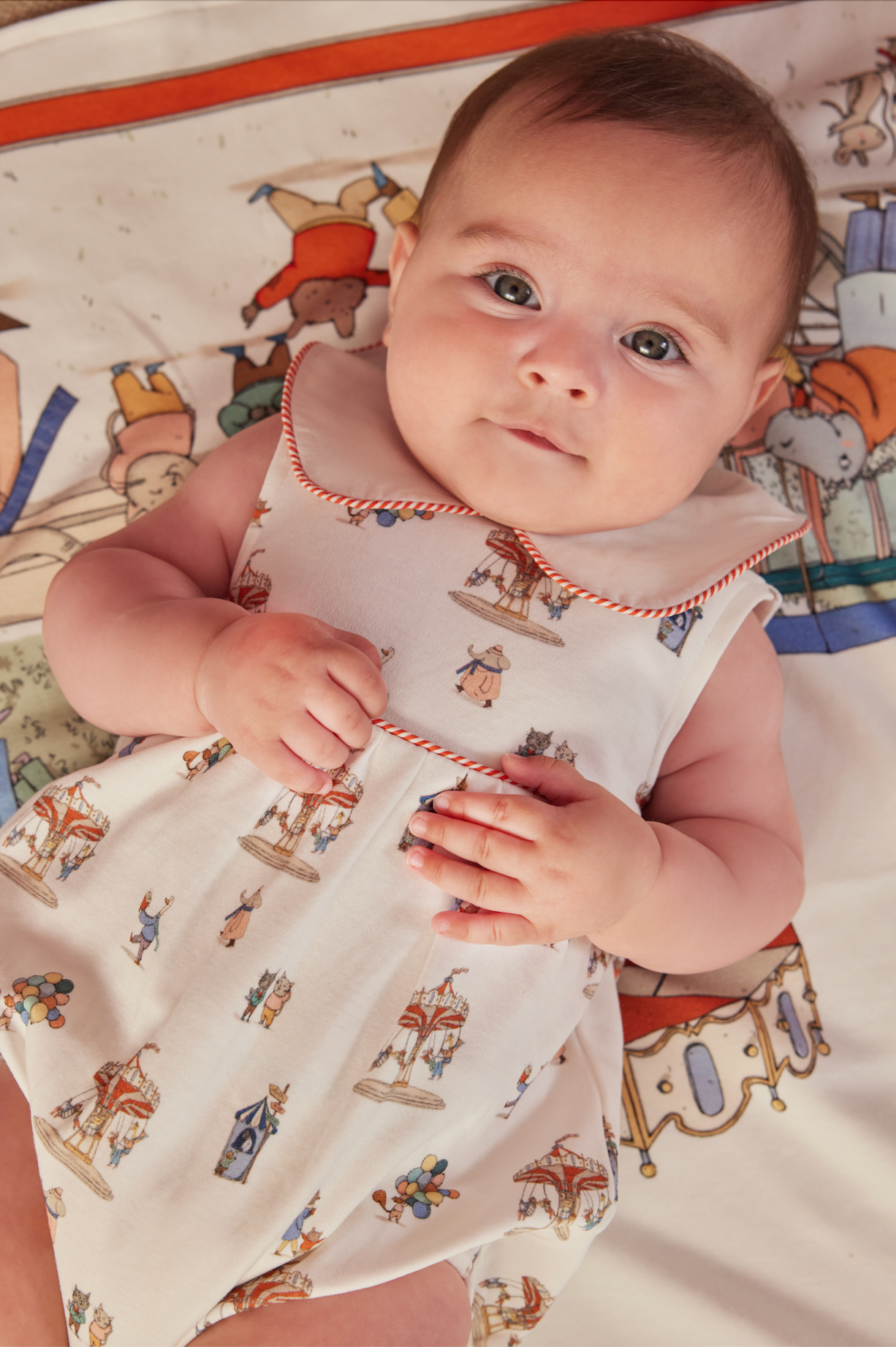 Baby wearing a onesie with carousel design on a colorful background